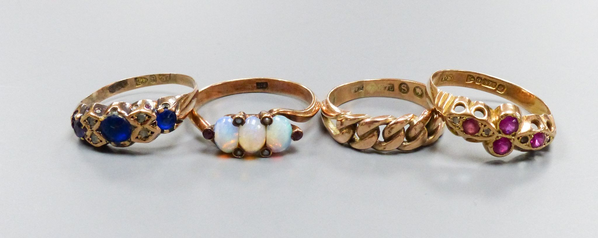 Four early 20th century 9ct gold and gem set rings including three stone opal with seed pearl spacers, gross weight 8.4 grams.